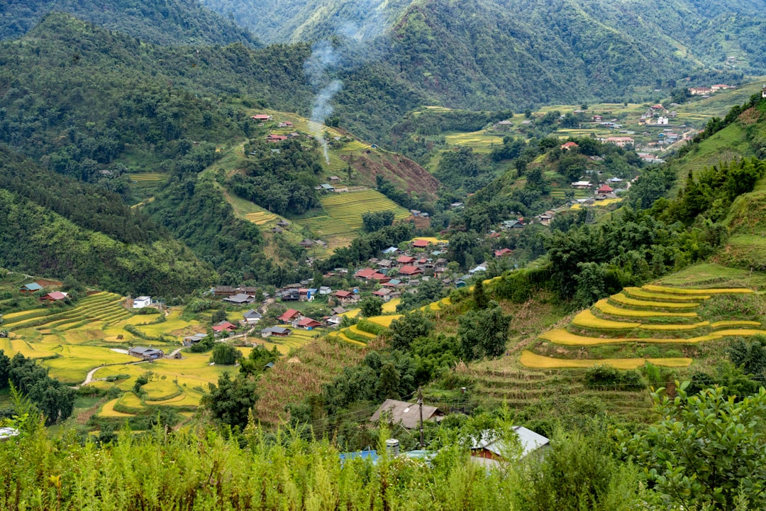 a village nestled in a valley surrounded by mountains,