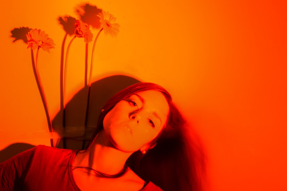 a woman with long hair standing in front of a wall