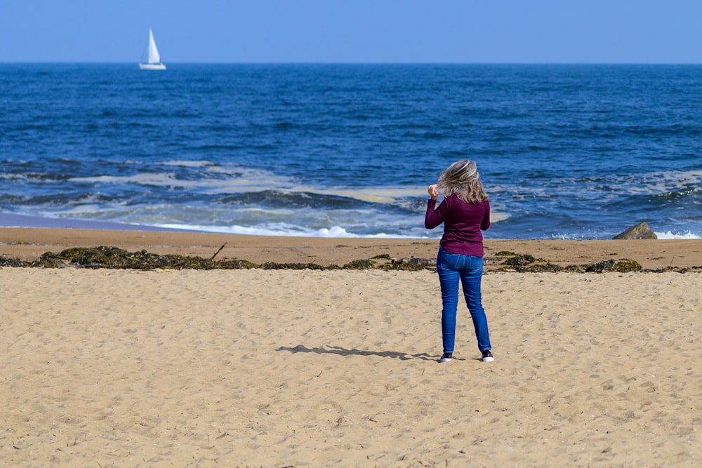 a woman standing on top of a sandy beach