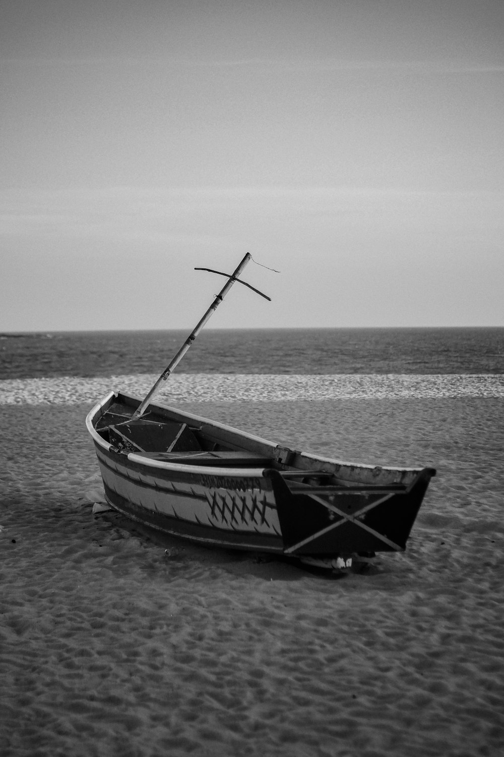 a boat sitting on top of a sandy beach