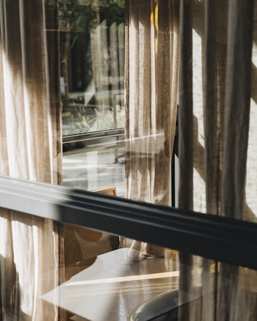 Soft natural light filtering through sheer curtains onto a sleek charcoal grey tabletop with bespoke accessories.