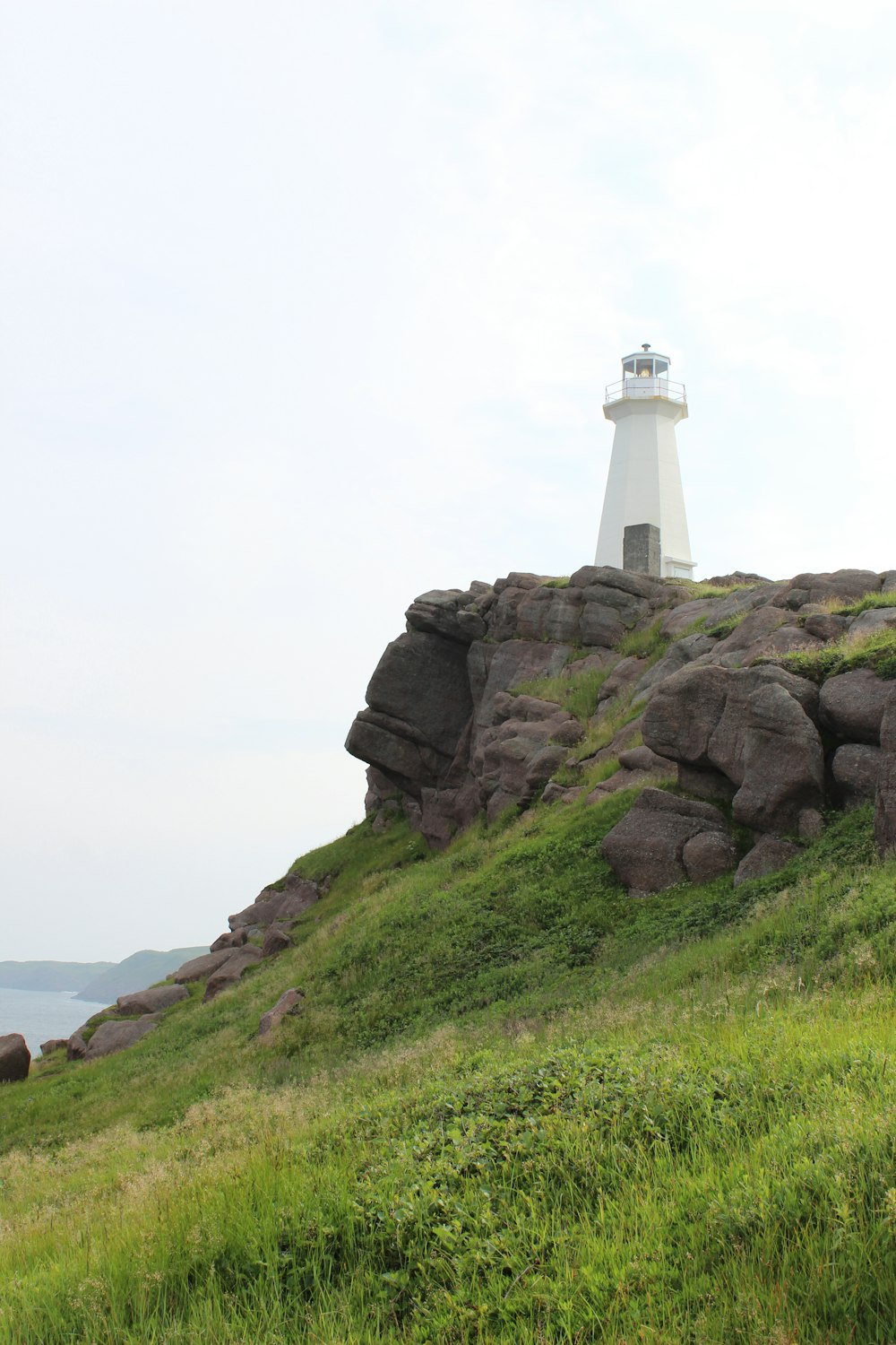 Un faro en la cima de una colina cubierta de hierba