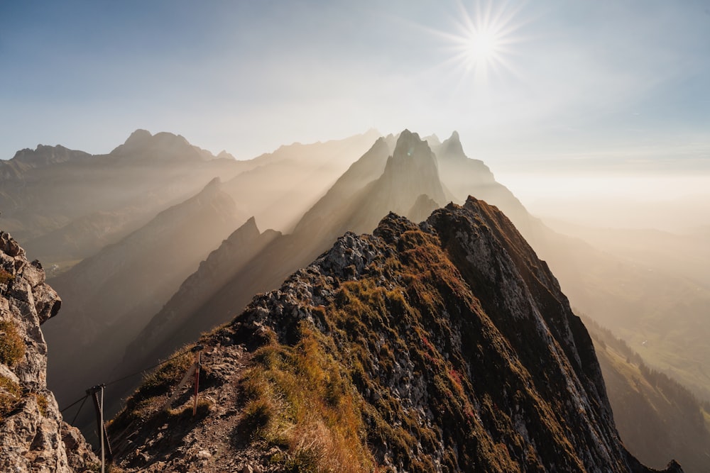 the sun shines brightly on a mountain peak