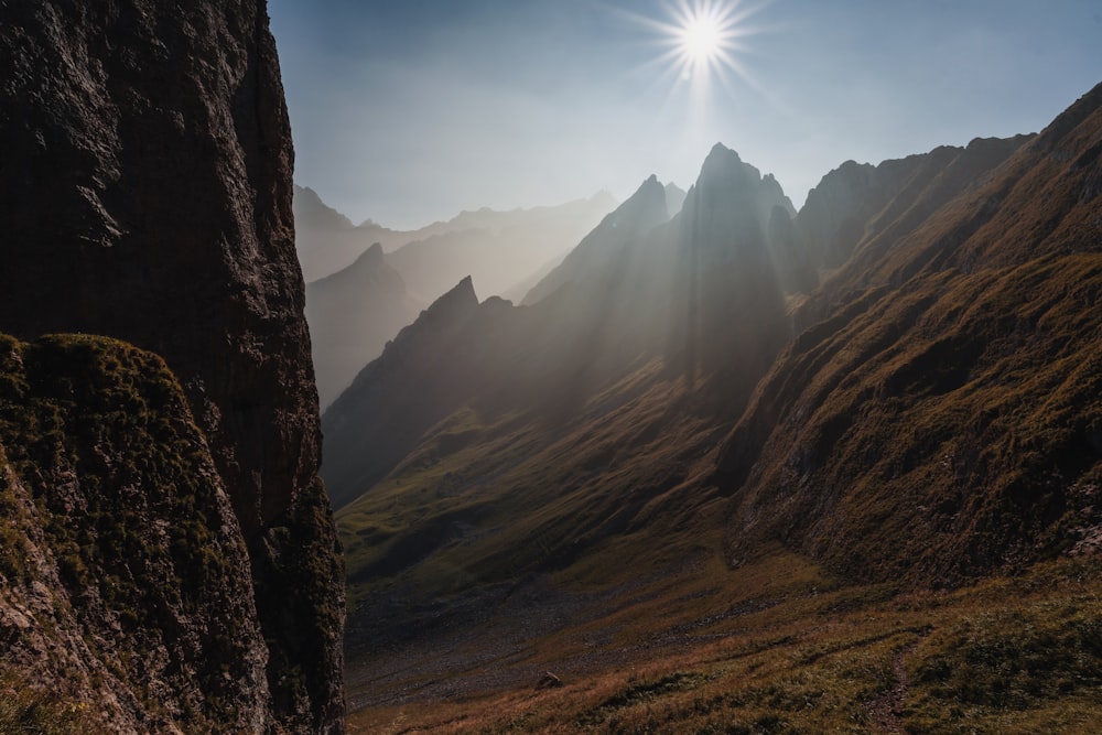 the sun shines brightly over a mountain range