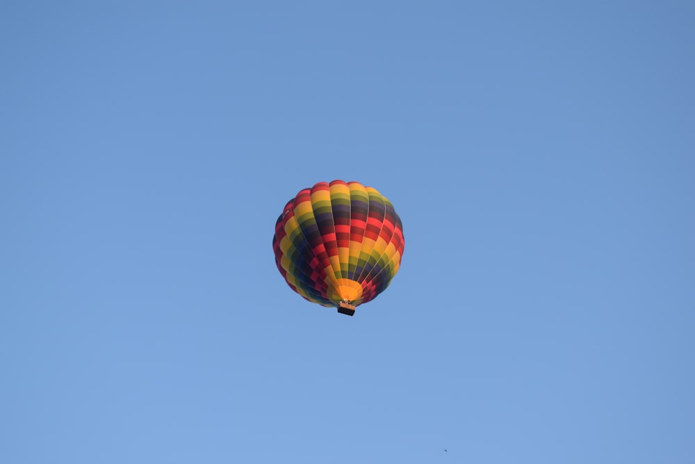 a colorful hot air balloon flying through a blue sky