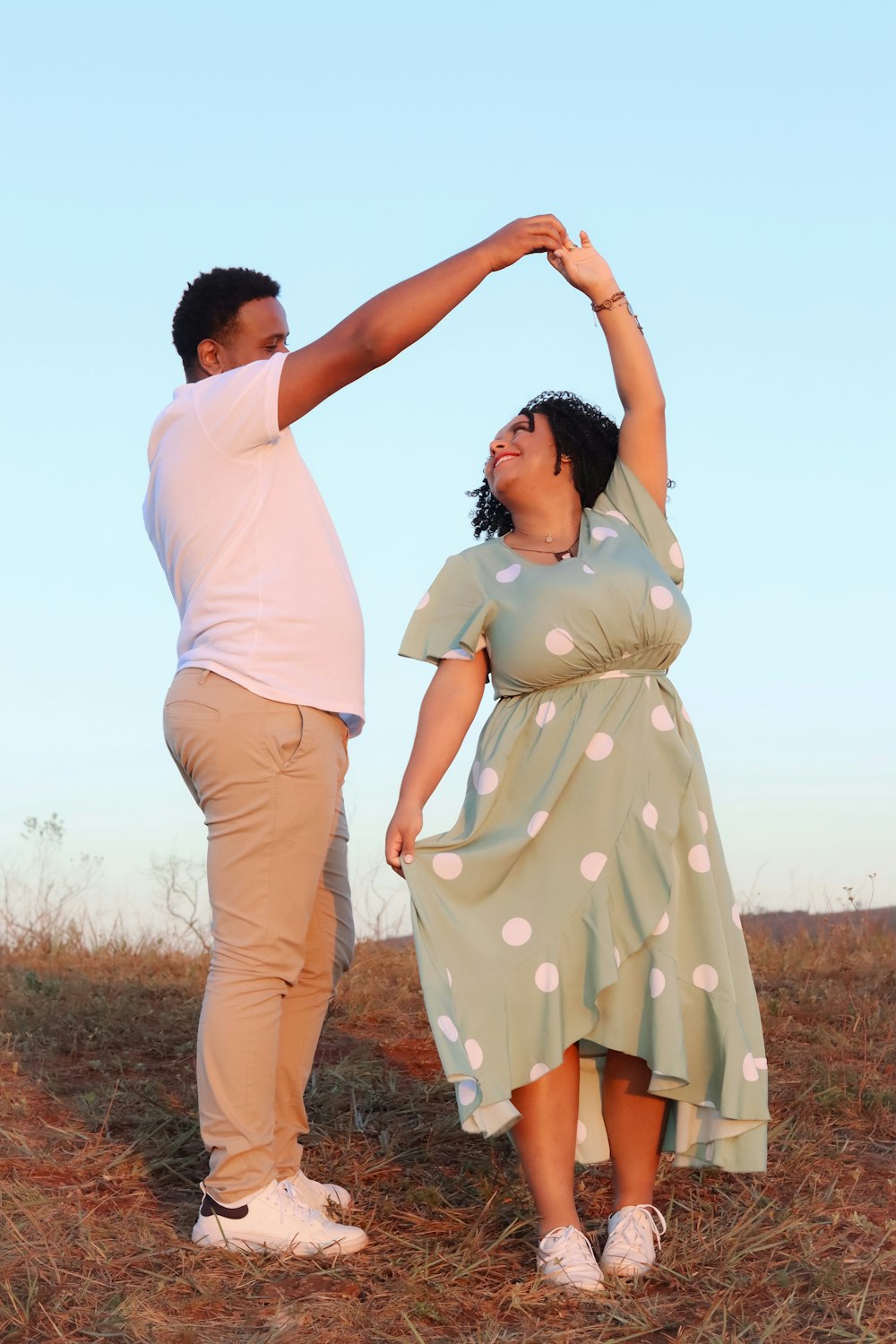 a man and a woman dancing in a field