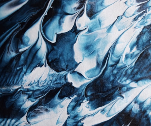 An abstract artwork featuring swirling patterns in shades of blue and white, resembling fluid, flowing waves or clouds. The composition is dynamic, with a sense of movement created by the intricate layering and blending of colors.