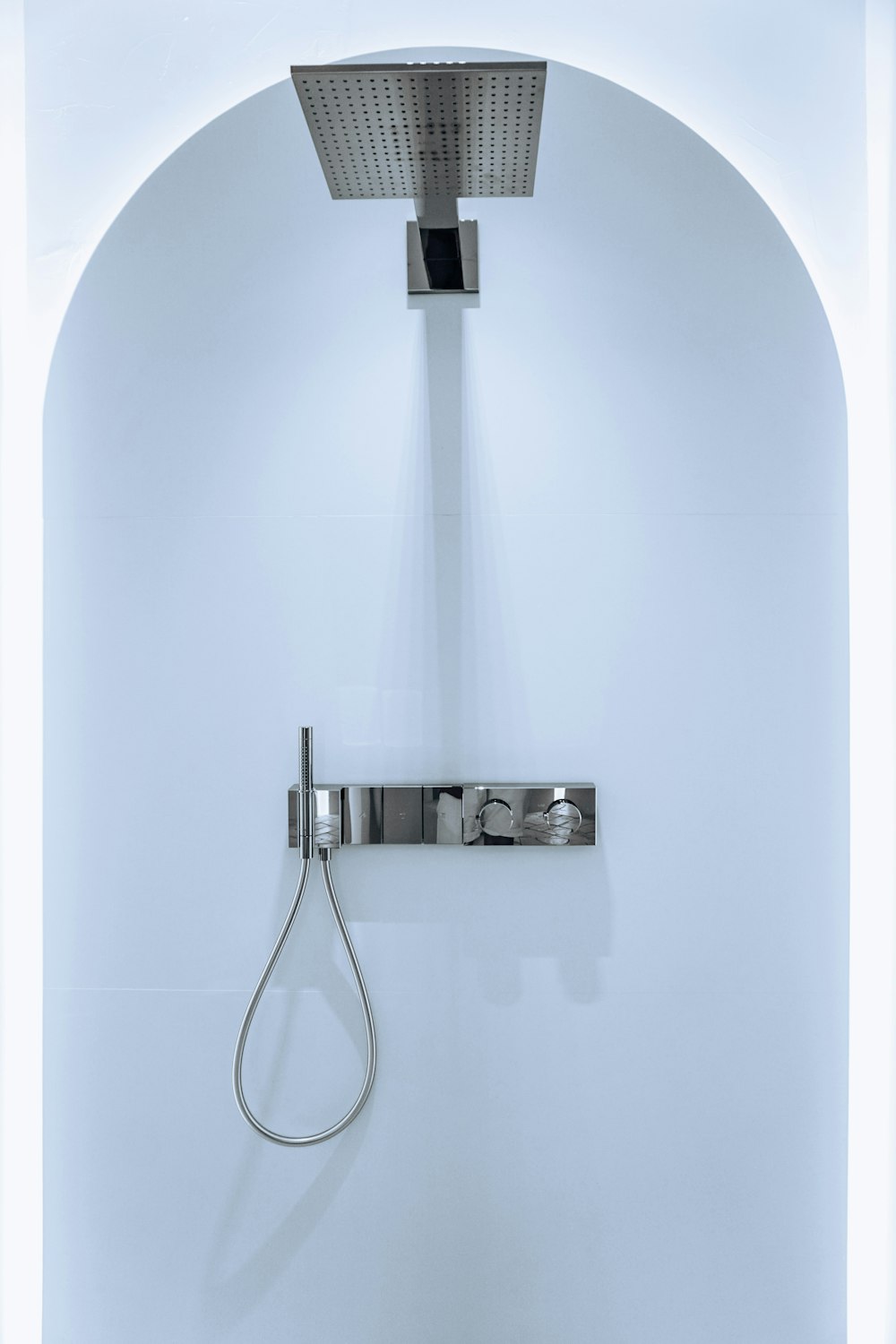 a shower head mounted to the side of a white wall
