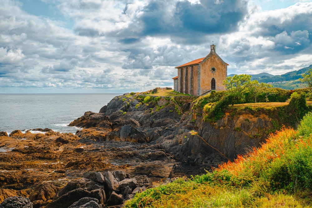 a small church on a rocky cliff by the ocean