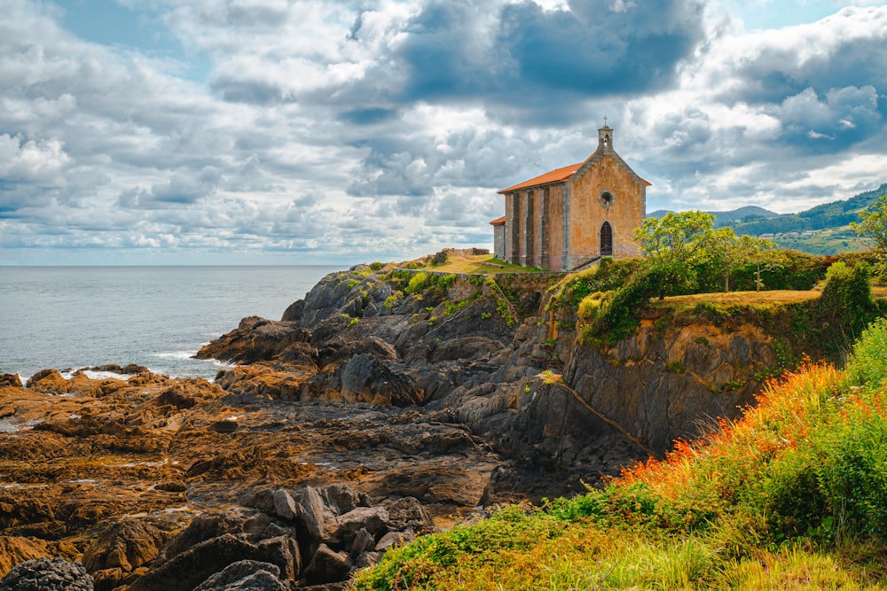 uma pequena igreja em um penhasco rochoso à beira-mar