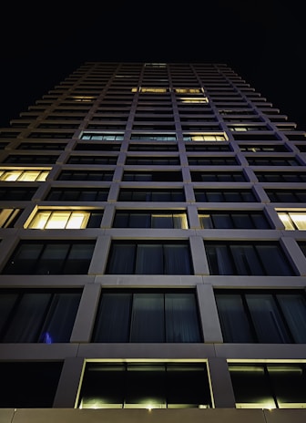 Night view of a high-rise building with clean lines and bold structure.