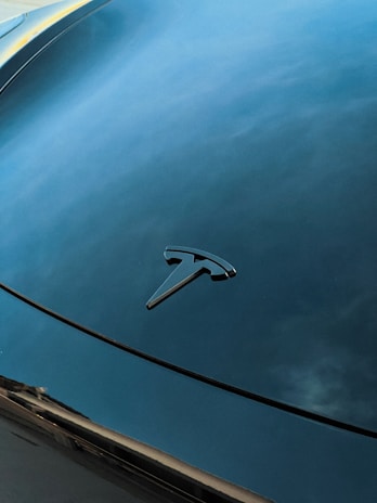 Close-up of a shiny car hood reflecting the clear blue sky, symbolizing quality and trust.