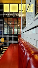 The cozy interior of Rougeslice with black and white decor accented by red touches, showing happy customers enjoying their meals.