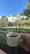 Hands holding a freshly brewed cup of coffee with city buildings blurred in the background.