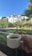 Smiling man holding a fresh coffee cup in a sunny coffee plantation.