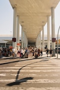 a group of people crossing a street under a bridge