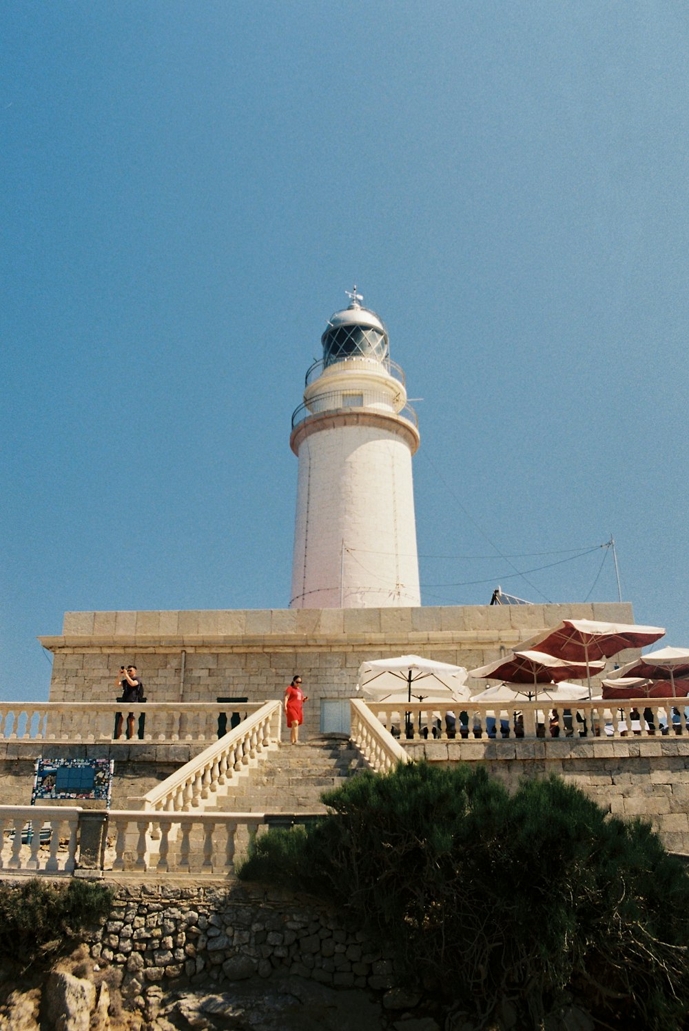 a large white lighthouse sitting on top of a cliff