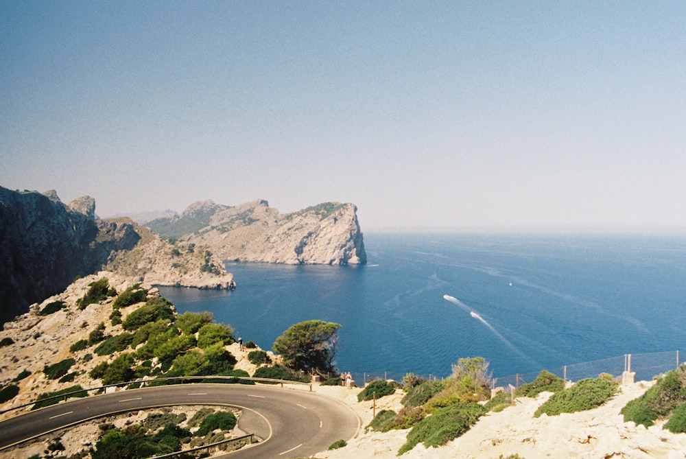 a winding road on the side of a cliff overlooking the ocean