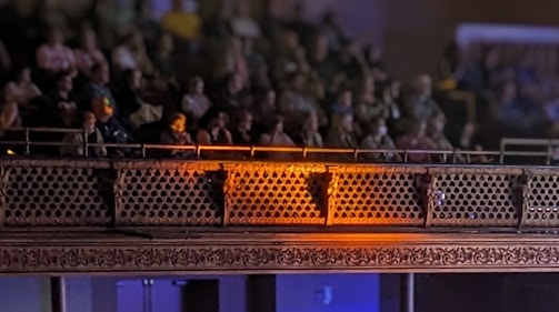 Audience applauding warmly in a cozy theater setting.