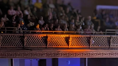 Audience smiling and applauding in a cozy theater hall.