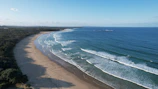 A serene coastal view of Ecuador’s shoreline with waves gently crashing on the beach.
