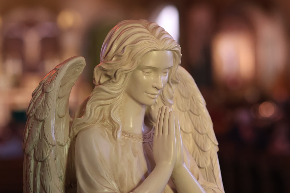 a statue of a praying angel in a church