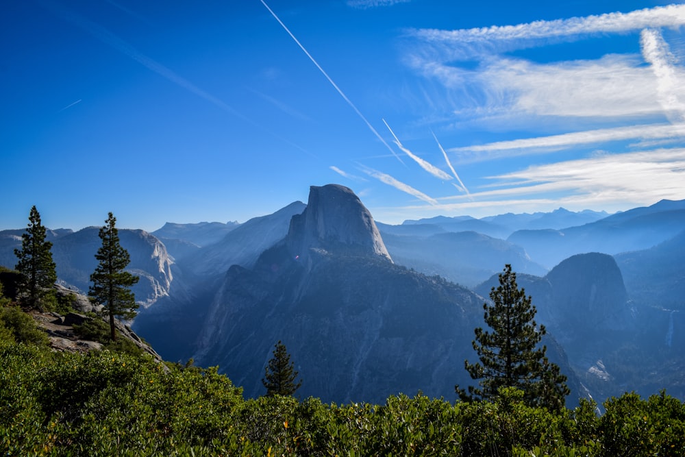 a view of a mountain range with trees and mountains in the background