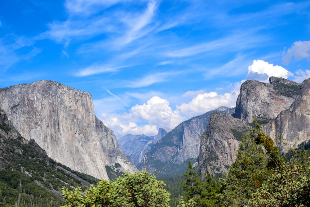 a view of a mountain range with trees and mountains in the background