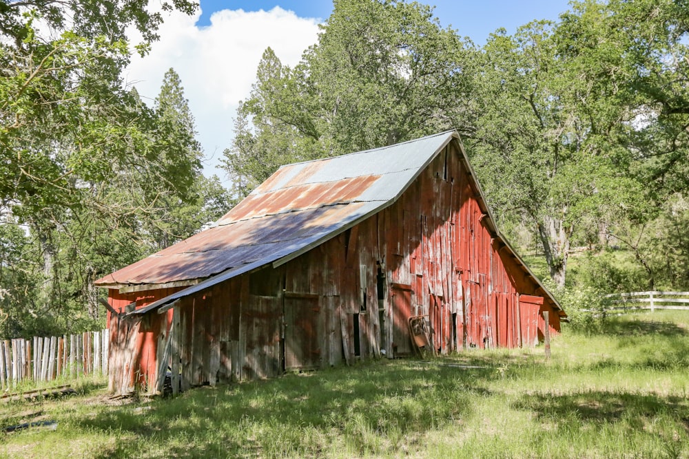 a red barn with a metal roof in a field