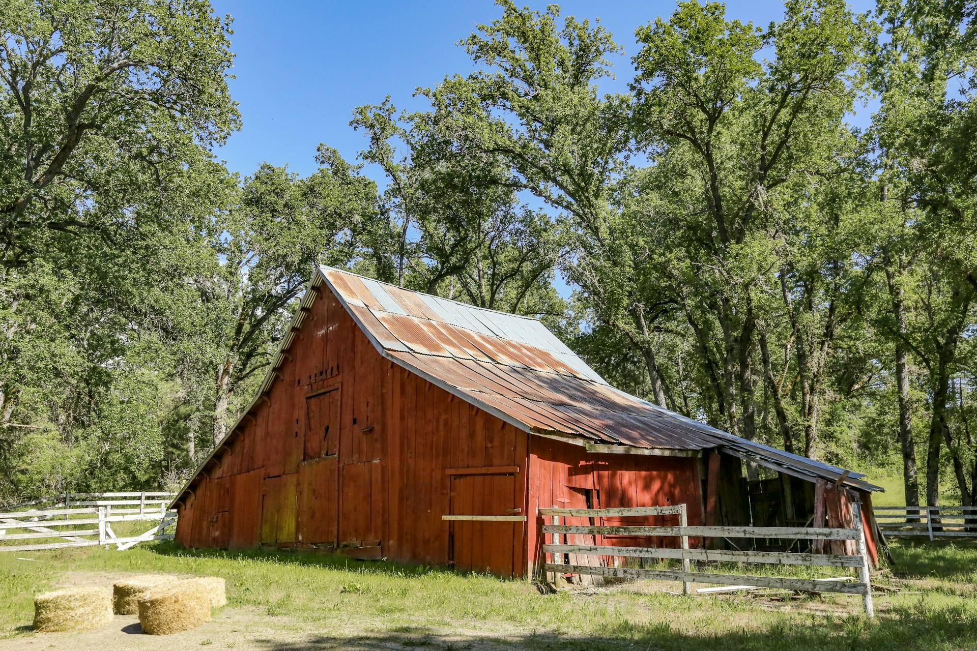 a red barn with a metal roof in a field