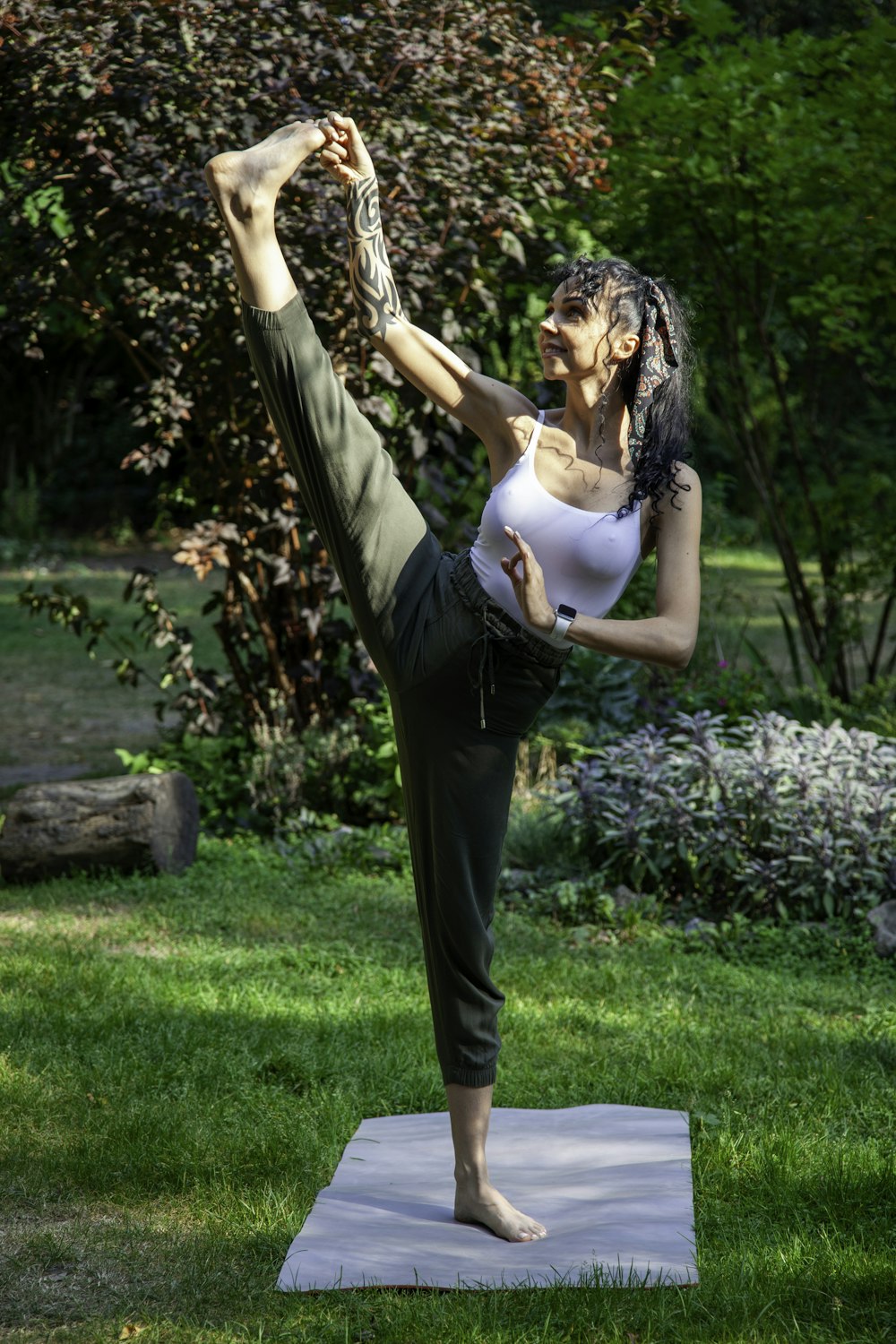 a woman doing a yoga pose in a park