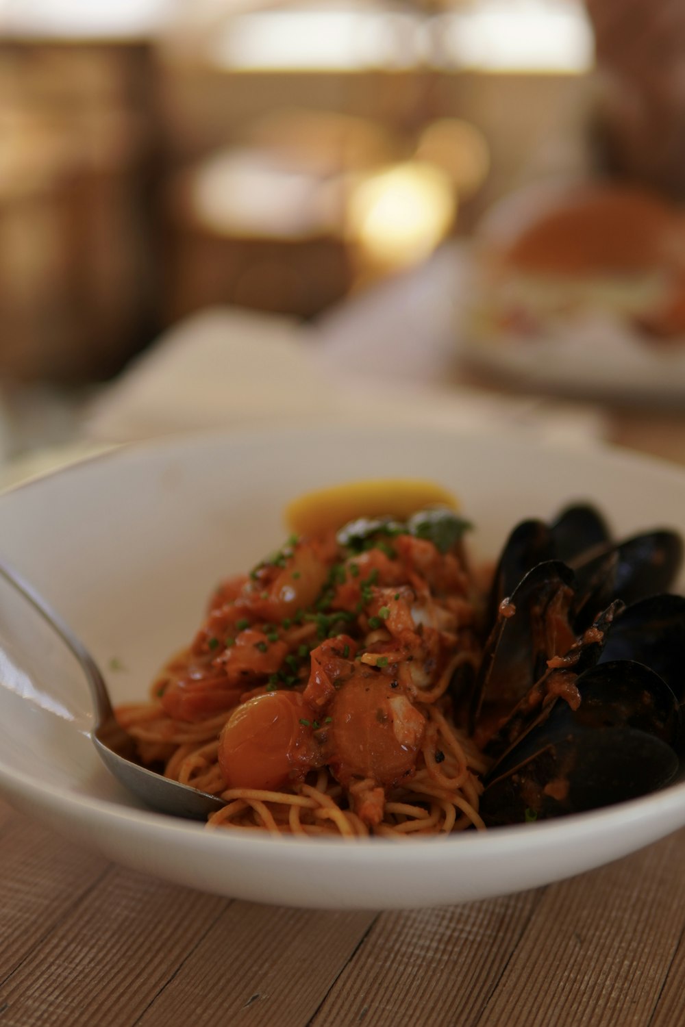 a bowl of pasta with mussels and sauce