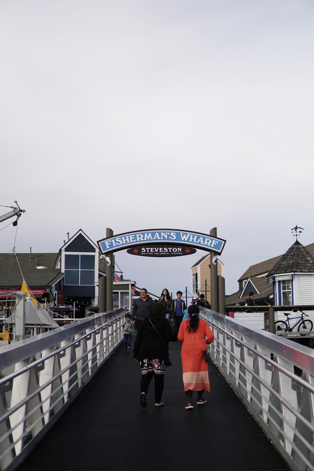 a group of people walking across a bridge