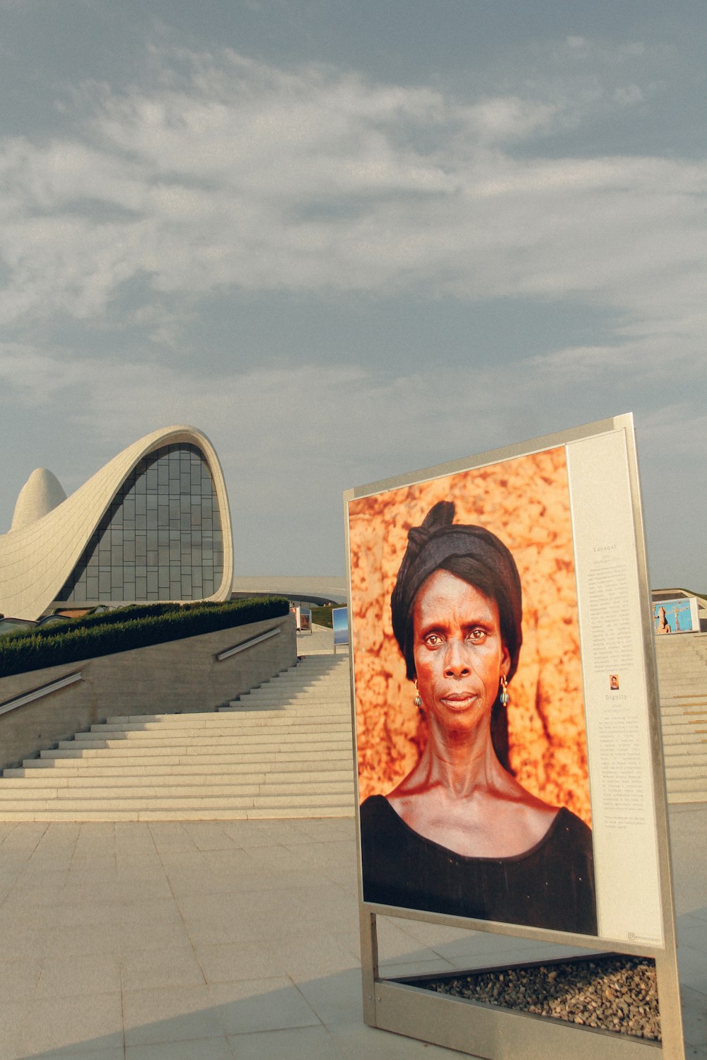 a portrait of a woman on display in front of a building