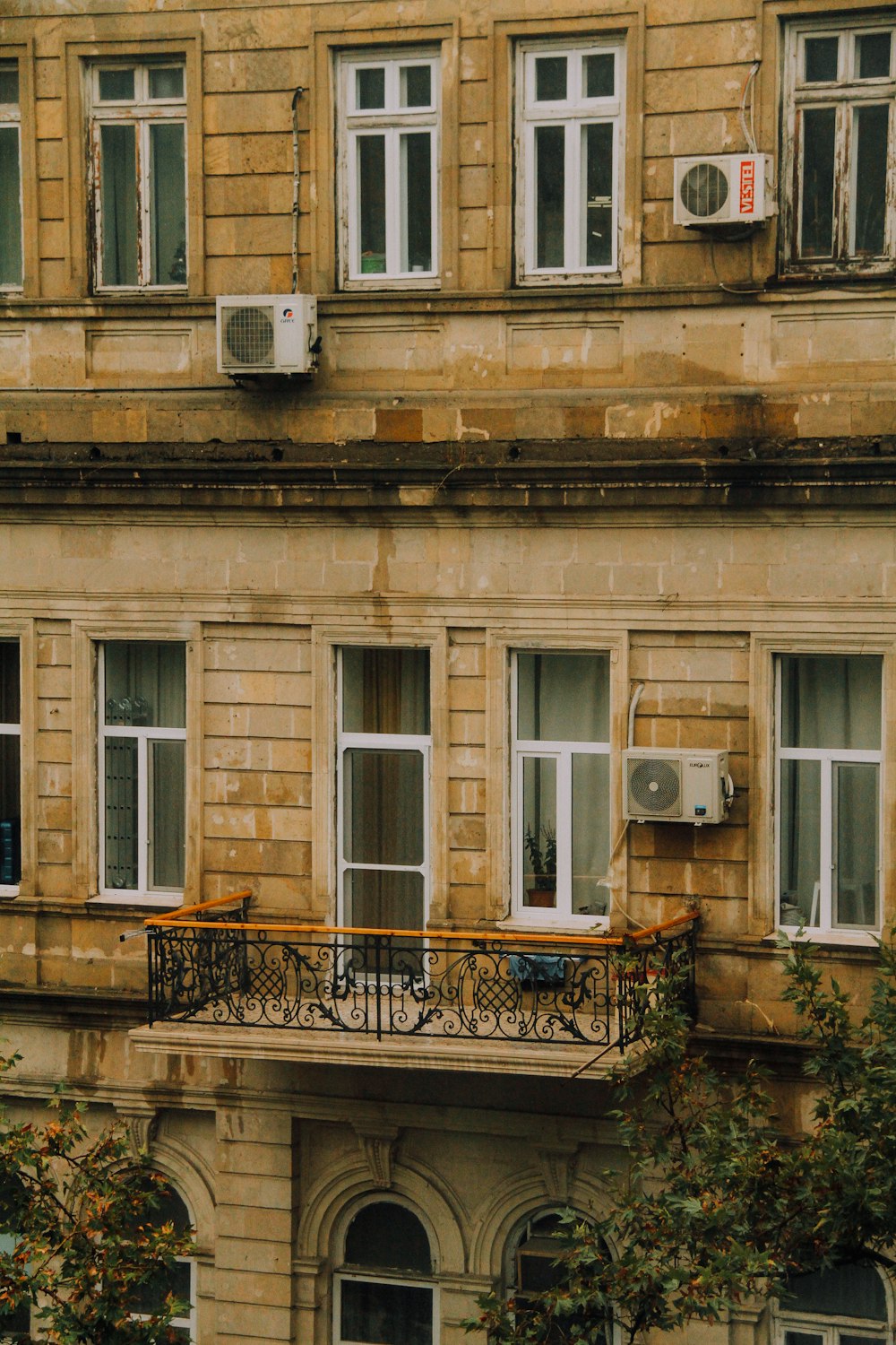 an apartment building with a balcony and air conditioner