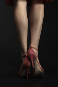 a woman's legs in high heels on a black background
