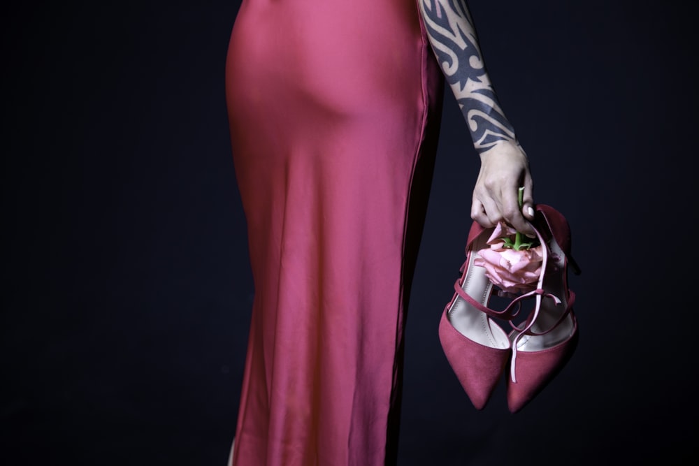 a woman in a pink dress holding a pink purse