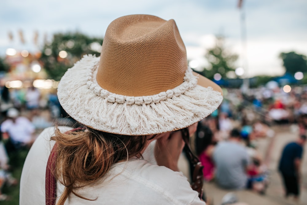 a woman wearing a brown and white hat