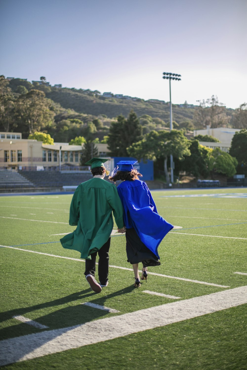 a couple of people that are walking across a field