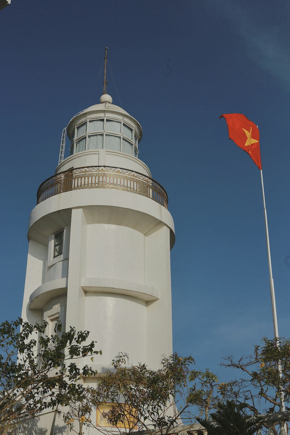 a large white tower with a red flag on top of it