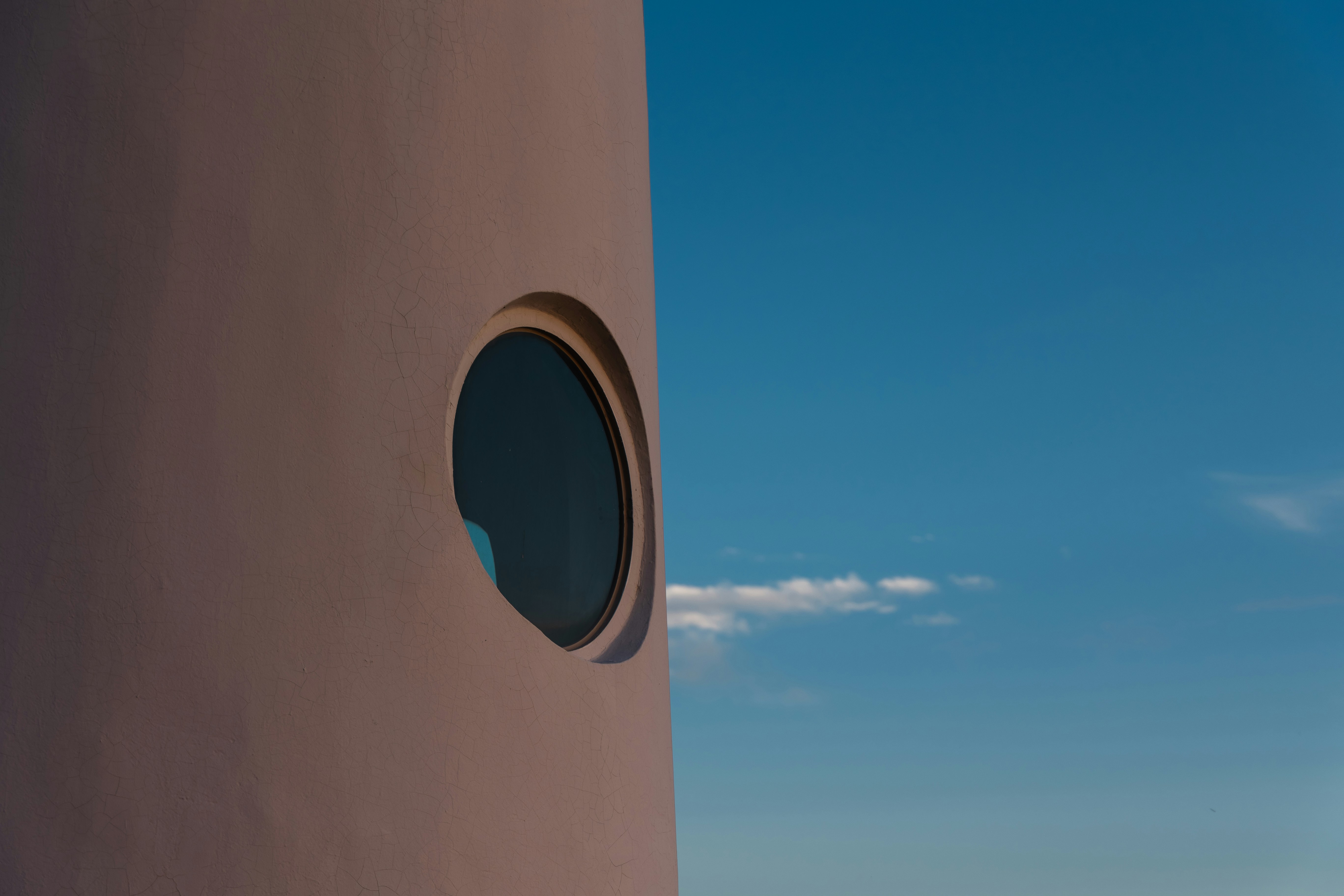 A round window on the side of a building photo – Free Texture Image on ...