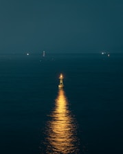 Picture of a lighthouse shining light over a calm sea, illustrating guidance and illumination.