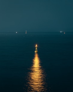 Picture of a lighthouse shining light over a calm sea, illustrating guidance and illumination.