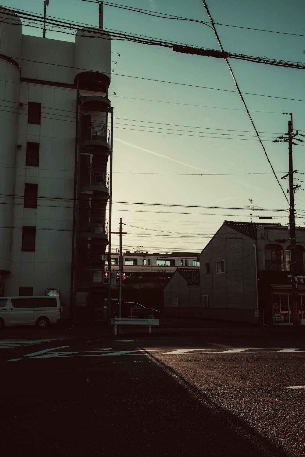 a white building sitting next to a street with power lines above it
