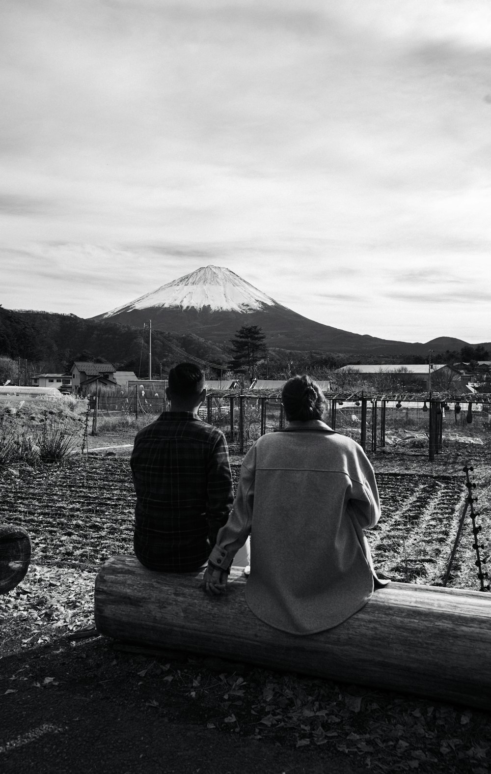 a couple of people sitting on top of a log