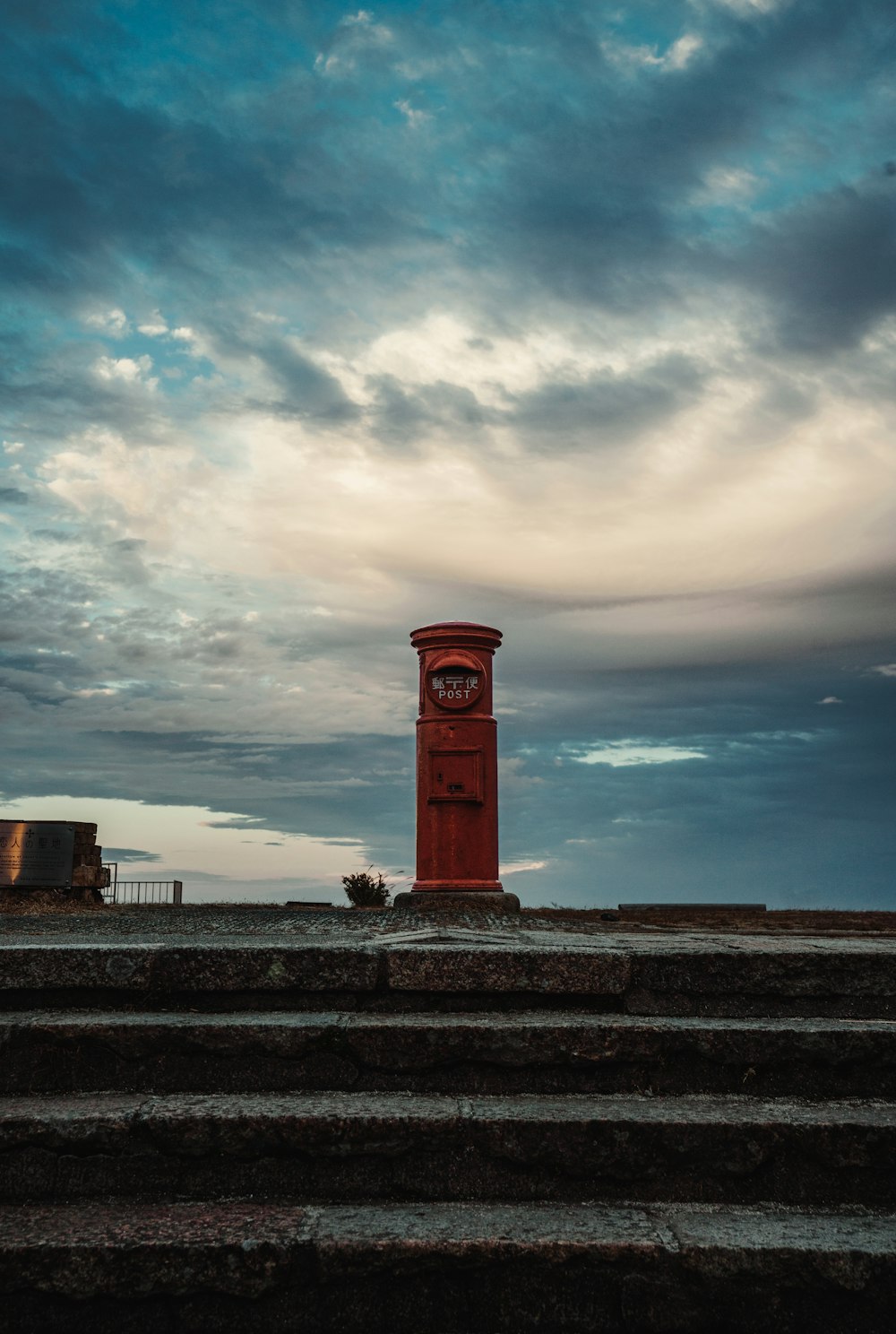 uma torre de relógio vermelha sentada no topo de um conjunto de degraus