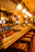 Cozy bar counter with warm lighting and a friendly hostess smiling.