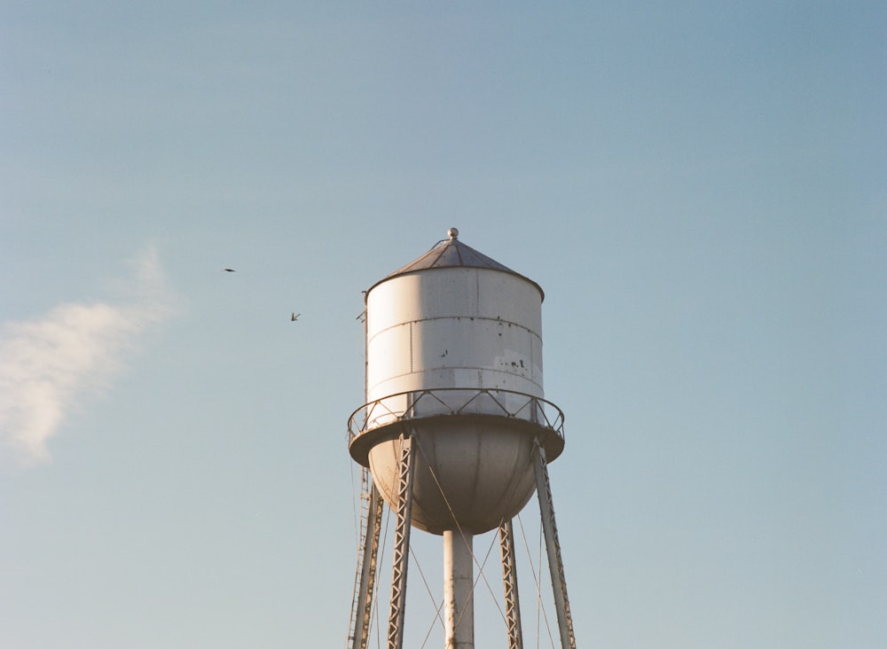 a large white water tower with a sky background