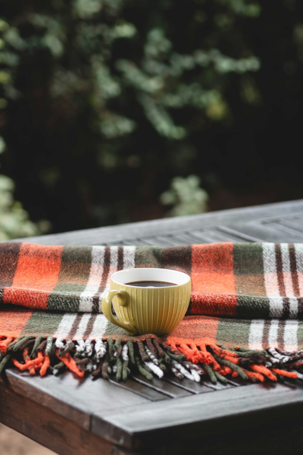 a cup of coffee sitting on top of a wooden table