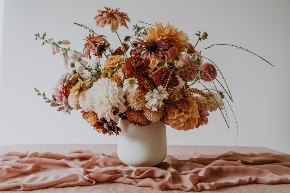 a vase filled with lots of flowers on top of a table